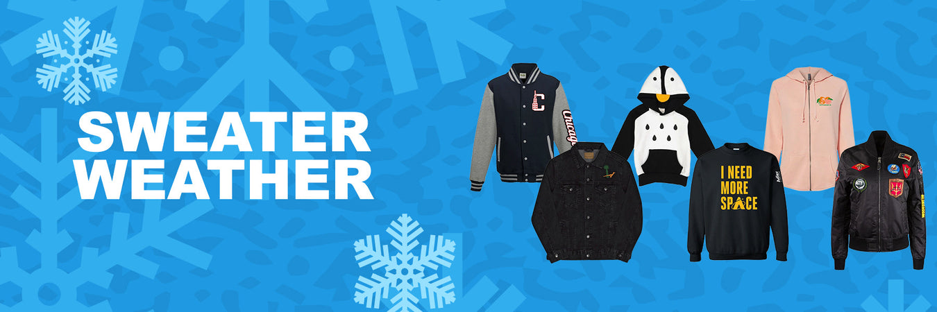 Sweater Weather banner displaying a varsity jacket, denim jacket, penguin hoodie, I NEED MORE SPACE sweatshirt, pink hoodie, and a bomber jacket covered in patches against a blue snowflake background.
