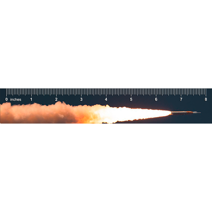 A rocket launching horizontally against an Artemis Ruler marked from zero to eight inches.