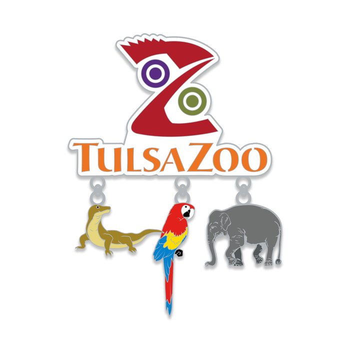 The Tulsa Zoo Dangle Magnet features a white background and three hanging charms—a Komodo dragon, colorful macaw, and gray elephant—making it a perfect souvenir that celebrates wildlife conservation.