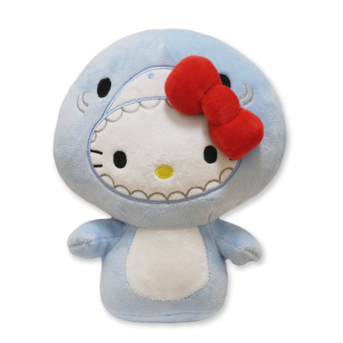 The Hello Kitty Shark Plush features Hello Kitty in a light blue marine life costume with a white belly and big red bow, set against a white background—a cute collectible for Sanrio fans.