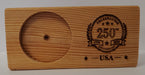 The USA 250th Anniversary Wood Coin Holder is a rectangular plaque made from reclaimed wood, with a left-side round slot for a USS Constitution coin and an engraved "Celebrating 250 Years USA" design with stars and laurels on the right.