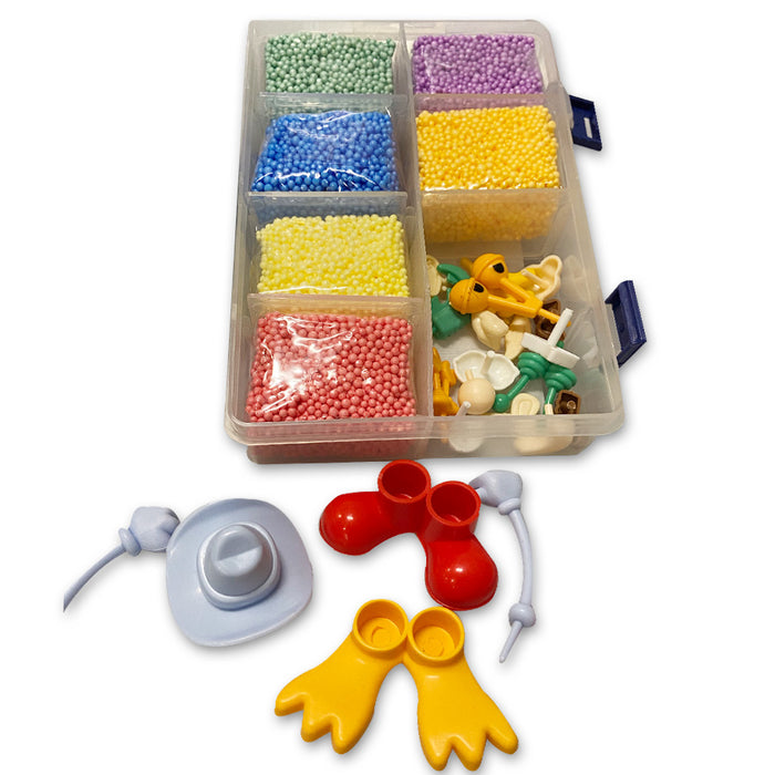 On the Go Fun Foam is a plastic organizer box with six compartments filled with squishable foam beads and assorted toy parts like hats, shoes, and wings, perfect for sparking creativity when spread out on a white background.