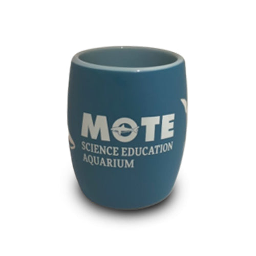 A clear shot glass etched with a shark design and the words “Mote Marine Laboratory,” celebrating Mote’s dedication to marine conservation.