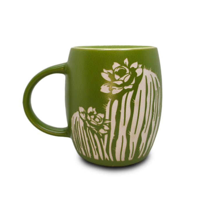 The Desert Botanical Garden Etched Mug features a green ceramic design with two white outlined cacti and succulent flowers inspired by Arizona native flora, making it a perfect botanical garden gift. The mug is displayed on a white background.