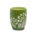 A small green ceramic Desert Botanical Garden Etched Shot Glass featuring white floral and leaf patterns inspired by desert flora on the exterior, displayed against a plain white background.