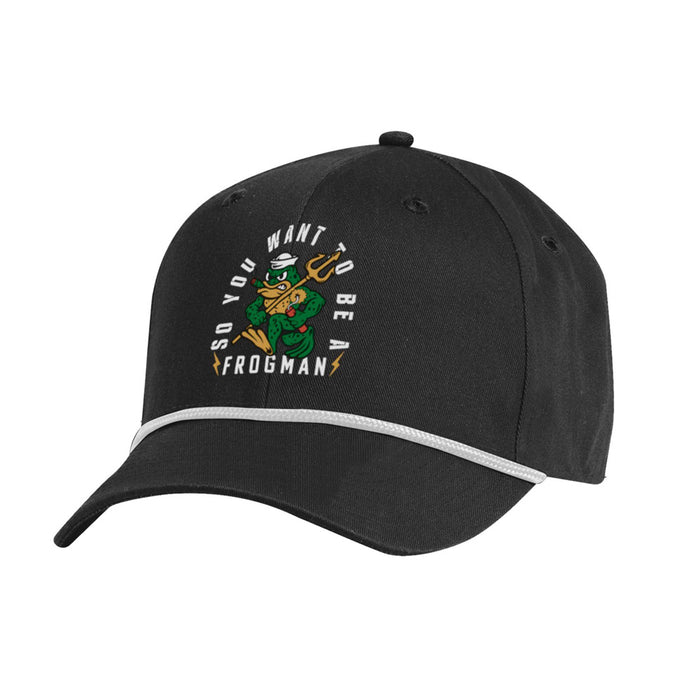 The Navy SEAL Museum Frogman Rope Cap features a black design with white trim and showcases an embroidered cartoon frog in a hat holding a trident. The words “SO YOU WANT TO BE A FROGMAN” appear above and below the frog, celebrating the legacy of the Navy SEALs. Available exclusively at the Navy SEAL Museum.
