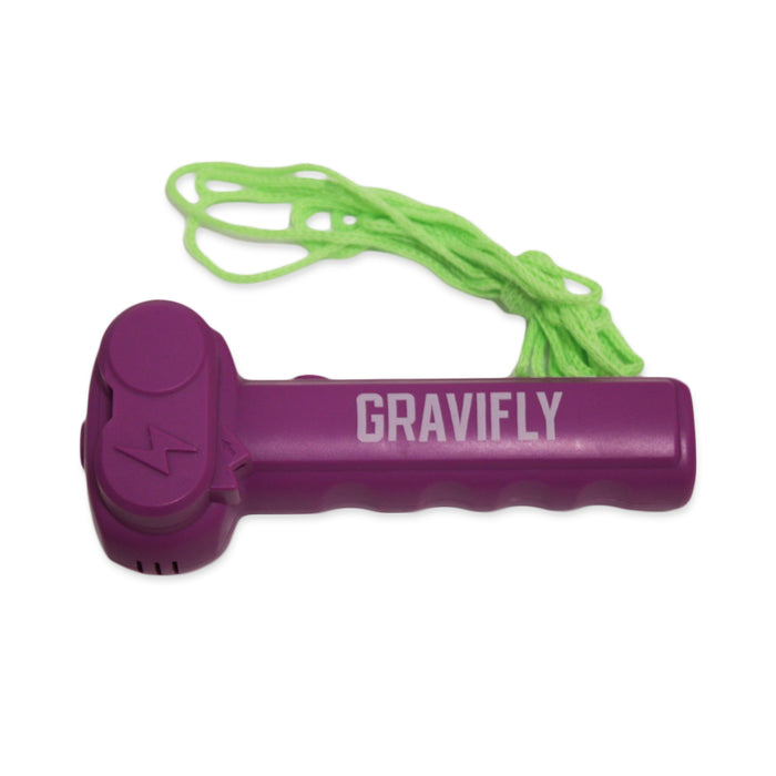 A purple Genius at Play GraviFly Rope Launcher with a textured grip and bright green string, set on a white background, highlights its gravity-defying design.