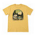 Mustard yellow Oregon Zoo Otter Scene T-shirt featuring a graphic of an otter by a river in a forest at sunset, with the text flanked by a pinecone and an acorn.