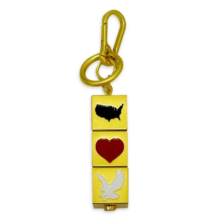 The USA Block Spinner Bag Clip features three square charms—a black U.S. silhouette, a red heart, and a white flying bird—stacked vertically for a stylish patriotic look.