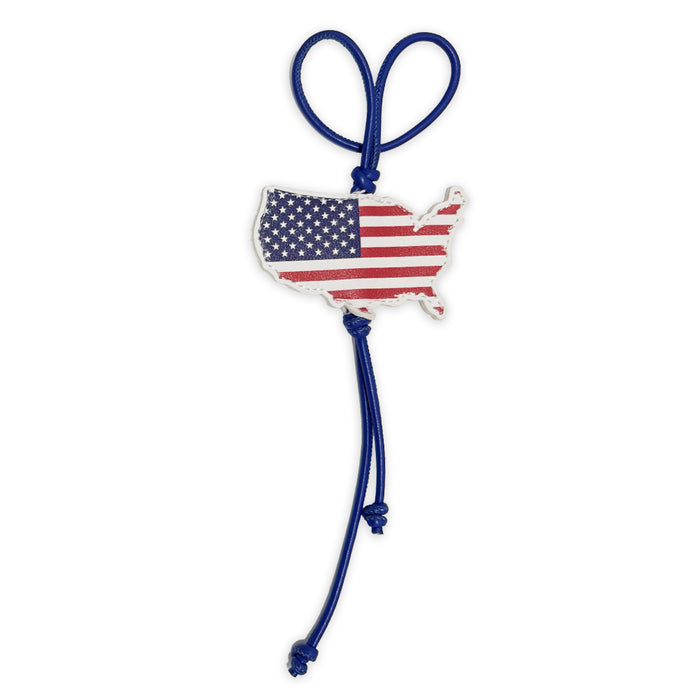 A blue knotted cord forms a loop and hangs from a USA-shaped charm featuring the American flag—making the USA Flag Bag Clip a stylish and patriotic accessory for your handbag.