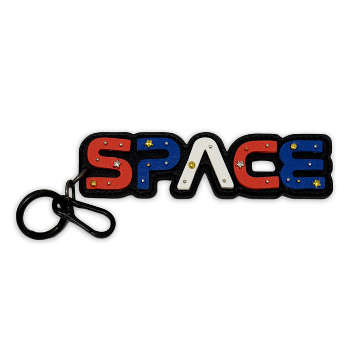 The Space Bag Clip is a bold keychain in red, white, and blue with star accents on a black metal ring—a cosmic accessory that’s perfect as a bag charm or dangle for any space enthusiast.