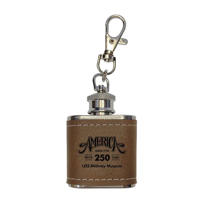 Introducing the USS Midway Museum America’s Birthday Concert Series Flask—a small brown leather flask keychain with “America Since 1776, United 250 Years, USS Midway Museum” printed on the front. It features a sturdy metal clasp at the top, making it an ideal keepsake for aviation enthusiasts and collectors celebrating naval aviation history from this iconic aircraft carrier museum.