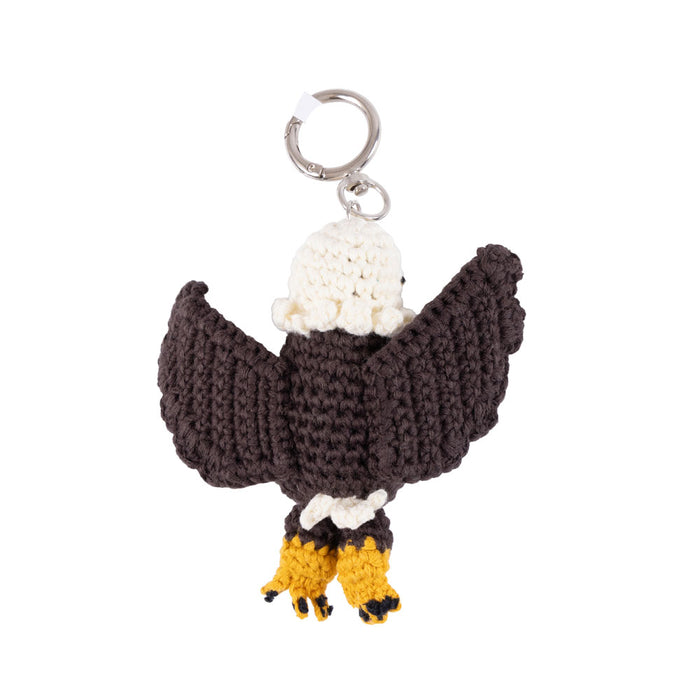 Introducing the Betsy Ross House Eagle Crocheted Bag Charm—a handcrafted keychain featuring dark brown wings, a white head, and yellow feet, shown from the back view. This charming accessory is attached to a silver key ring and makes an ideal patriotic keepsake or a unique souvenir from historic sites like the Betsy Ross House.