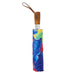 Closed Painter’s Palette Travel Umbrella featuring a wood-toned handle and a colorful, swirling abstract paint pattern.