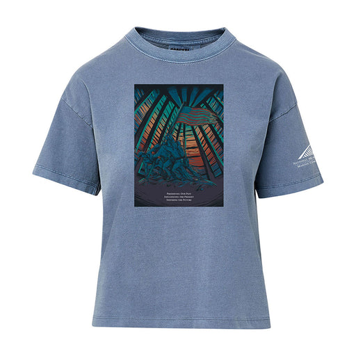 The National Museum of the Marine Corps Building Women’s T-Shirt features a colorful graphic of soldiers raising a flag with rays and a sunset in the background, plus text beneath the image. A small white logo inspired by the National Museum of the Marine Corps appears on the left sleeve, making this a standout patriotic shirt for women.