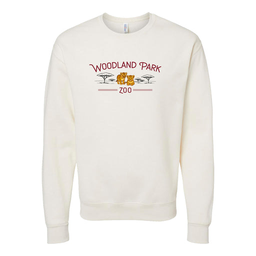 The Woodland Park Zoo Baby Lion Crew Sweatshirt is cream-colored with a red and yellow print of two trees, a lion, and the zoo's logo on the front—an adorable way to support wildlife conservation.
