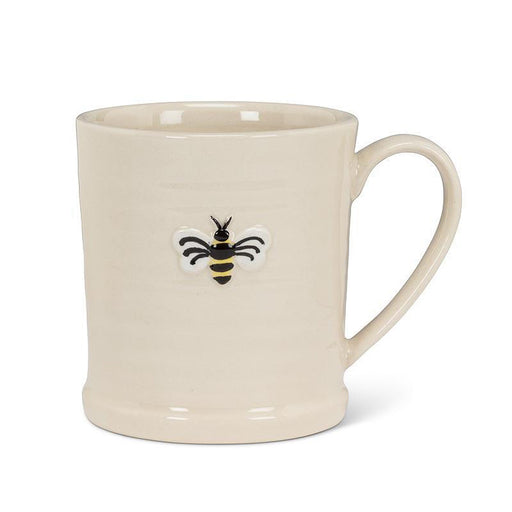 The Bee on Rimmed Mug is a cream-colored stoneware mug with a handle and a small raised bee design—ideal for your morning coffee.