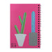 The Desert Botanical Garden Will Beger Green & Blue Cactus Notebook is a spiral-bound notebook with a vibrant pink cover, decorated with illustrations inspired by the Desert Botanical Garden. The design features two cacti in patterned pots: a green cactus in a white pot on the left, and a taller blue and green cactus in a gray pot on the right, evoking Will Beger’s playful artistic style.
