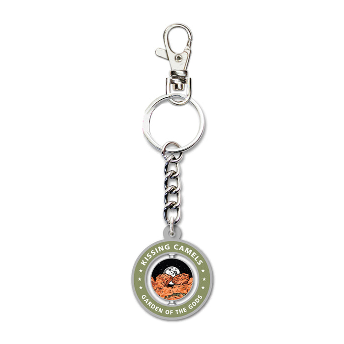 Introducing the Garden of the Gods Kissing Camels Spinner Keychain—a round keychain with a durable metal chain and clip. The spinning charm showcases vibrant imagery of red rock formations with “KISSING CAMELS GARDEN OF THE GODS” encircling the border in bold white letters, making it a perfect Colorado souvenir for fans of Garden of the Gods.