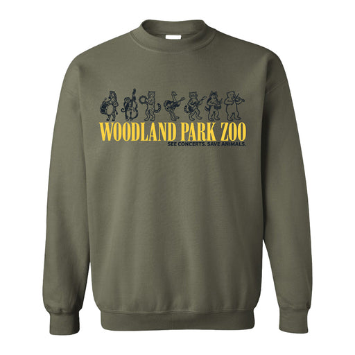 The Woodland Park Zoo Marching Menagerie Crew Sweatshirt is olive green, displaying cartoon animals dancing above yellow "WOODLAND PARK ZOO" text and the smaller caption "SEE CONCERTS. SAVE ANIMALS." to celebrate wildlife conservation.