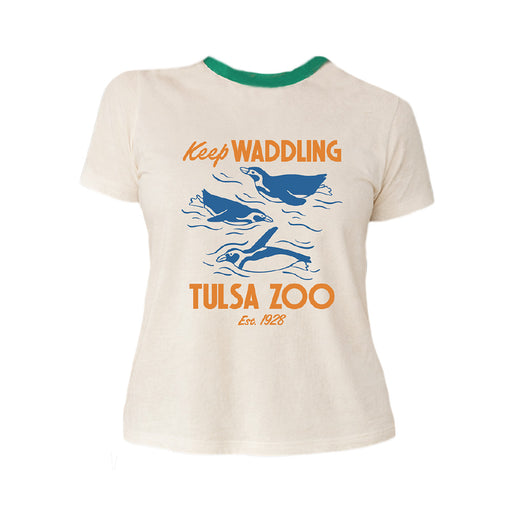 The Tulsa Zoo Penguin Sporty Pop Ringer T-Shirt is white with green trim, features blue penguin illustrations and orange "Keep Waddling Tulsa Zoo Est. 1928" text, and is made of organic cotton—perfect for sustainable fashion fans.