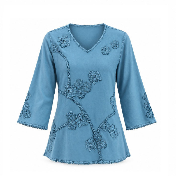 Teal Embroidered Women’s Top featuring a V-neck and intricate floral embroidery on the front, sleeves, and hem. Made from eco-friendly materials, this long-sleeve blouse embodies sustainable fashion with its soft, flowing look and decorative edge stitching.