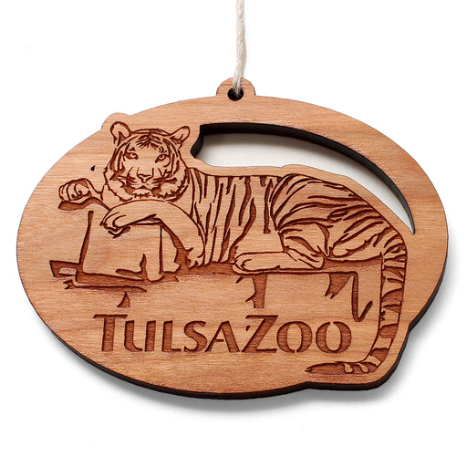 The Tulsa Zoo Tiger Wooden Ornament showcases wildlife conservation with a detailed engraving of a reclining tiger and “Tulsa Zoo” below. It features a top hole and string for easy hanging.