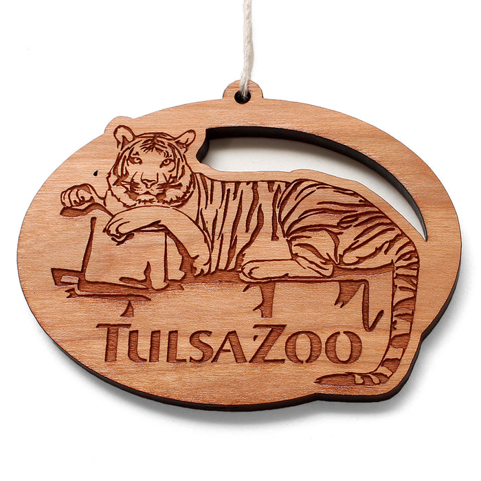 The Tulsa Zoo Tiger Wooden Ornament showcases wildlife conservation with a detailed engraving of a reclining tiger and “Tulsa Zoo” below. It features a top hole and string for easy hanging.