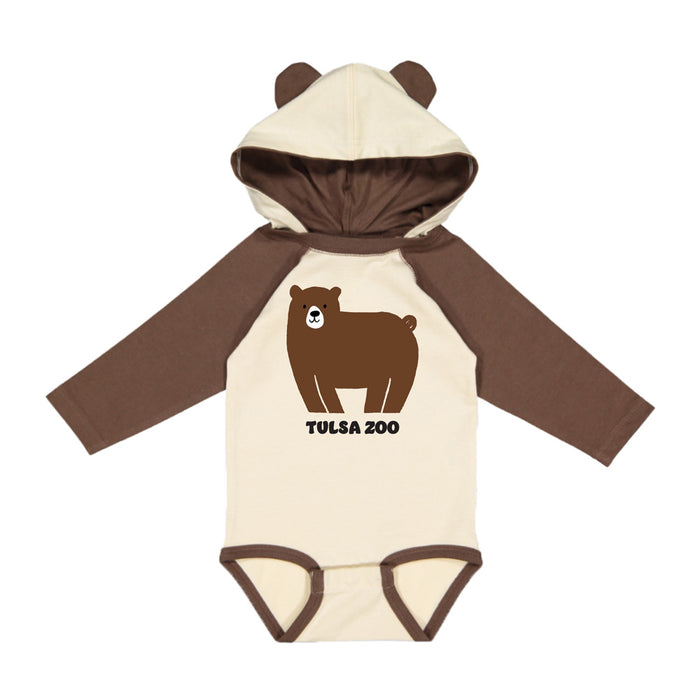 The Tulsa Zoo Bear Hooded Onesie is a beige and brown infant onesie with a hood featuring bear ears, a cute cartoon bear on the front, and “Tulsa Zoo” text—ideal for keeping your little one cozy and playful.