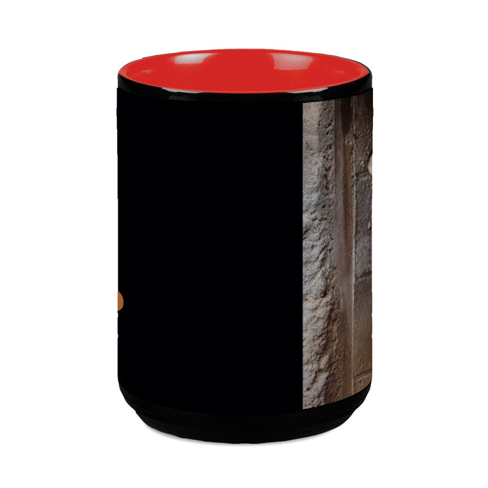 The Tulsa Zoo Portraits of Conversation Tiger Mug features a black exterior, bright red interior, and a partial stone wall image—perfect for supporting tiger conservation and wildlife education.