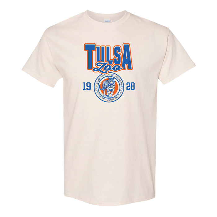 The Tulsa Zoo Collegiate Tiger T-Shirt is cream-colored with "Tulsa Zoo," "1928," bold orange and blue accents, and a circular tiger head logo—perfect for showing your support for wildlife conservation.