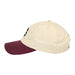 The Mob Museum Two-Tone Dad Cap, shown from the side, features a beige crown with a maroon brim. This classic dad cap includes stitched eyelets and a top button for a timeless look and comfortable fit.