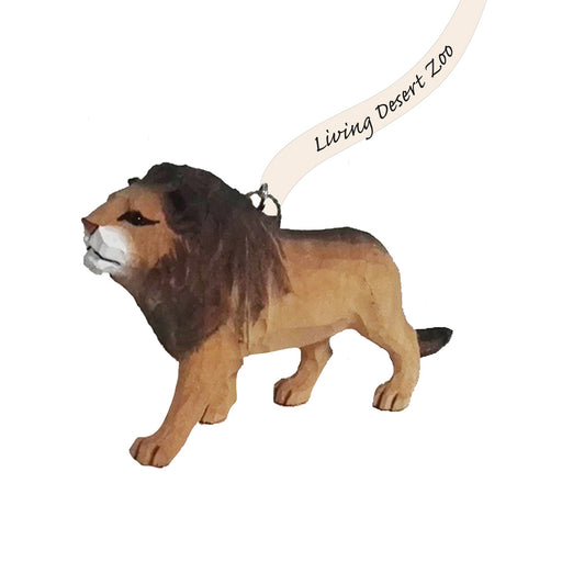 The Living Desert Zoo and Gardens Lion Wood Ornament is a small figurine featuring a lion with a brown mane, standing on all four legs against a white background. With a string attached to its back and the zoo’s name proudly displayed, this charming keepsake captures the spirit of wildlife conservation.