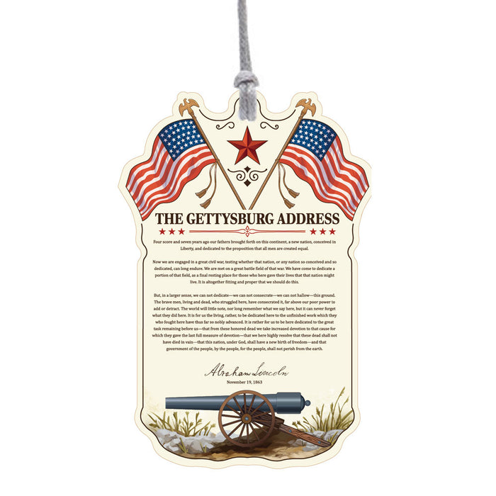 Gettysburg Address ornament shaped like a shield, topped with an American flag and framed by cannons and a drum at the base.