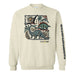 Cream sweatshirt featuring a graphic of dinosaurs, a sun, and foliage with the text phoenixzoo and a column of geometric shapes printed on the sleeve.