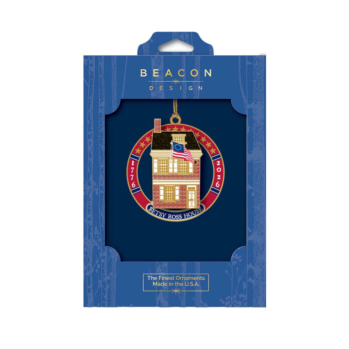 A Betsy Ross House 250th Ornament featuring an American flag, dated 1776–2026, displayed in its blue packaging.