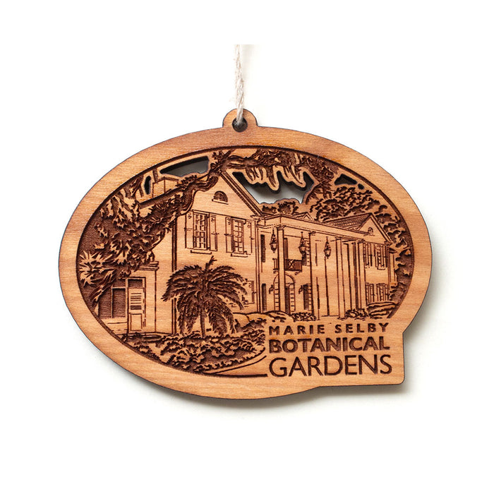 Marie Selby Botanical Gardens Building Ornament, an oval-shaped wooden piece featuring a laser-cut illustration of a historic home with palm trees and a Marie Selby Botanical Gardens inscription.