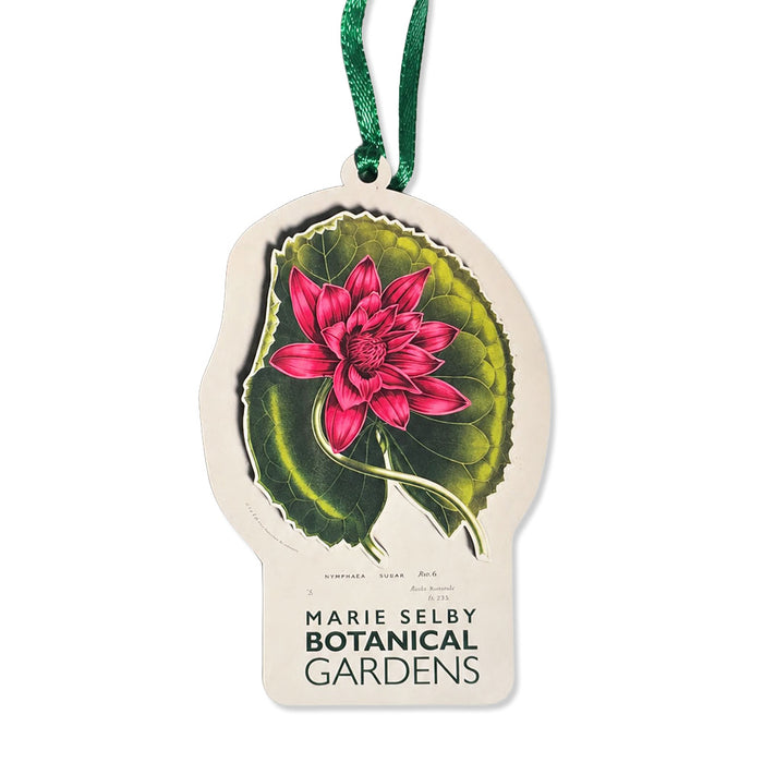 Marie Selby Botanical Gardens Watercolor Rubra Ornament, a die-cut hanging decoration featuring a pink water lily on a green lily pad with botanical text and the Marie Selby Botanical Gardens logo below.