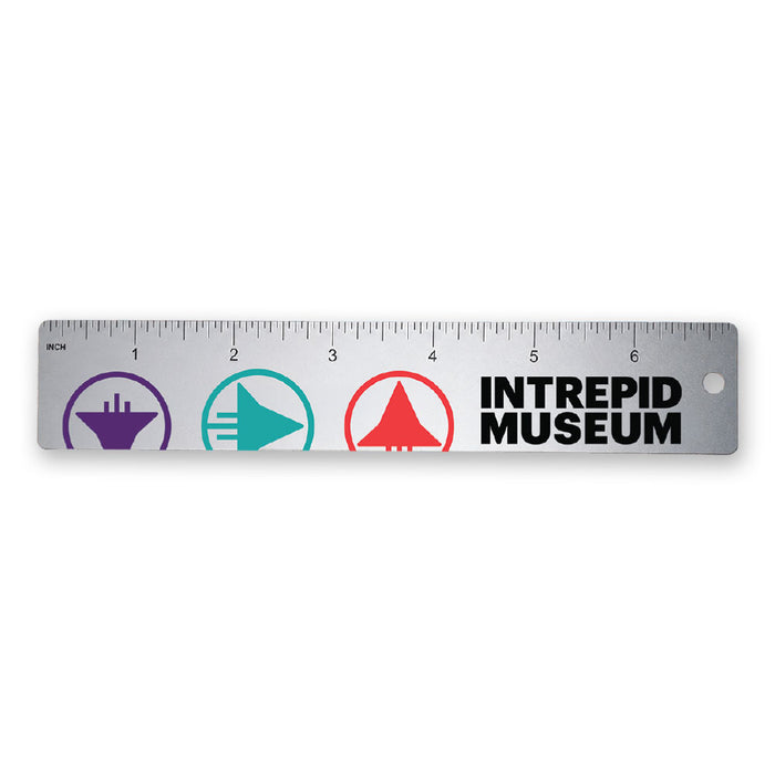 Introducing the Intrepid Museum Ruler—a silver ruler featuring black measurement markings, vibrant silhouette icons of ships and planes, and bold black INTREPID MUSEUM text on the right. This educational accessory honors scientific innovation.