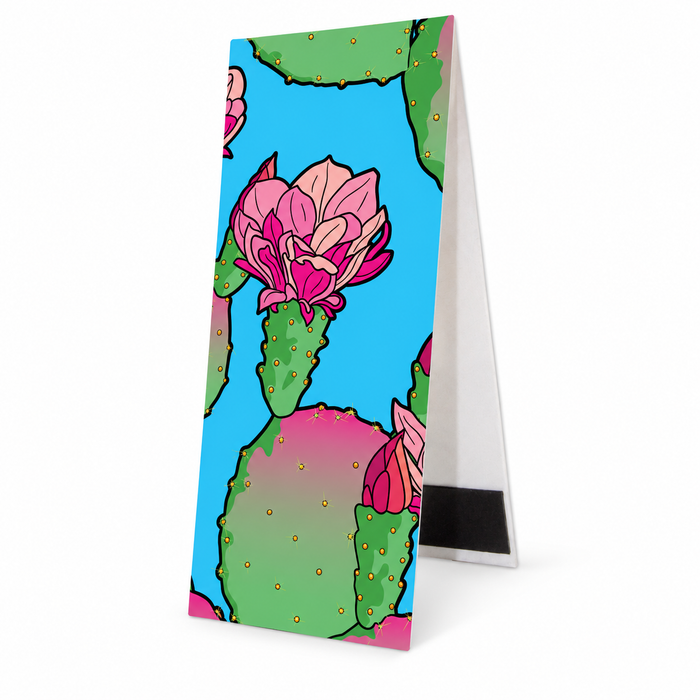 The Desert Botanical Garden Superbloom Bookmark features a pattern of green prickly pear cactus pads with bright pink flowers against a blue background, inspired by desert botanical art.