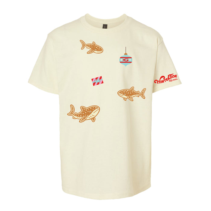 Off-white Georgia Aquarium Whale Winter Tide Youth T-Shirt with a repeating pattern of gingerbread whale sharks, holiday ornaments, and gifts, featuring the text Winter Tide on the sleeve.