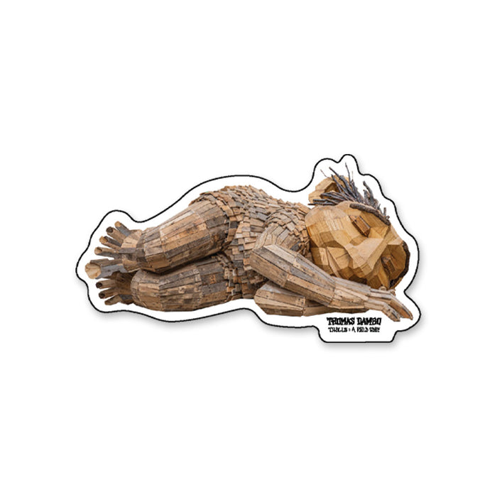 Thomas Dambo, Trolls Field Study Sticker featuring a die-cut design of a wooden troll sculpture lying on its side with the text Thomas Dambo Trolls: A Field Study at the bottom.