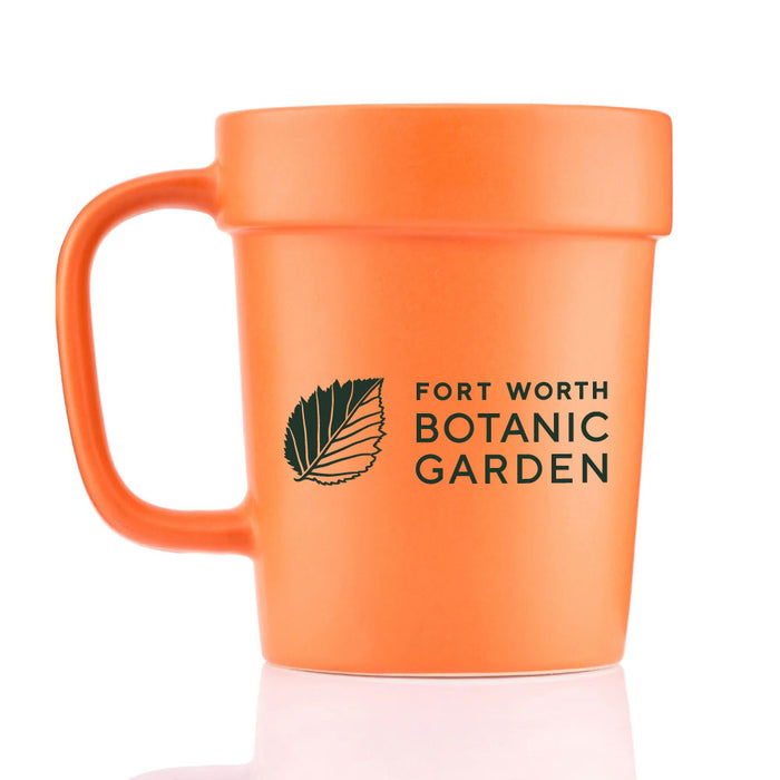 Orange Fort Worth Botanical Garden Planter Mug shaped like a flower pot, printed with a black leaf icon and the text Fort Worth Botanic Garden.