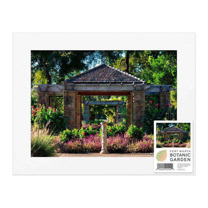 A matted Fort Worth Botanical Garden Trellis Mounted Print showing a stone walkway in a garden, with a small rectangular label in the bottom right corner featuring the garden’s name, address, and a barcode.