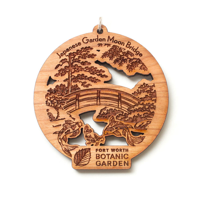 Fort Worth Botanical Garden Wood Ornament featuring a round, laser-cut design of a Japanese moon bridge, koi fish, and trees, inscribed with the garden name as a botanical keepsake.