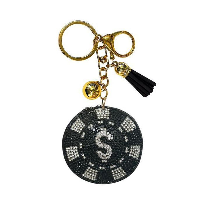The Bling Poker Chip Bag Charm features a gold keychain adorned with a black and white rhinestone poker chip charm, a small gold bell, and a black tassel, all attached to a gold keyring and clasp. It’s the perfect poker accessory or card game gift for any enthusiast.