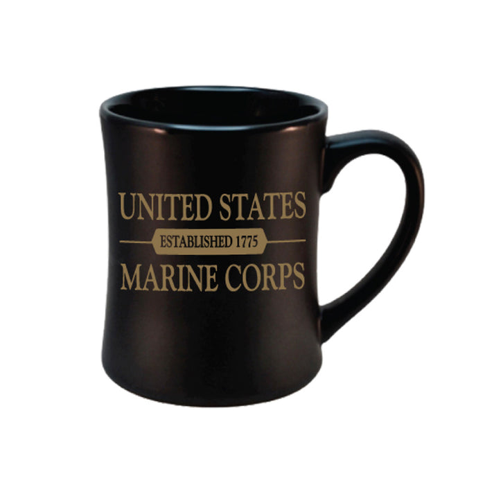 The United States Marine Corps Diner Mug is a patriotic black coffee cup with gold text in the center that reads “United States Marine Corps” and “Established 1775.”.