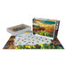 A Desert Colors Saguaro Flowers 1000pc Puzzle in progress, featuring a desert landscape with cacti, shown with its box and a tray of loose pieces.