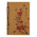 The Cherry Blossom Journal features a brown cover with string binding, adorned with elegant Chinese calligraphy and an illustration of a branch with red blossoms.