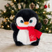 A Puffimals Penguin Plush with large blue eyes, wearing a red scarf with a white snowflake design.